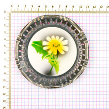 Size demonstration of a 1920s Metal & Ceramic Yellow Flower Coaster